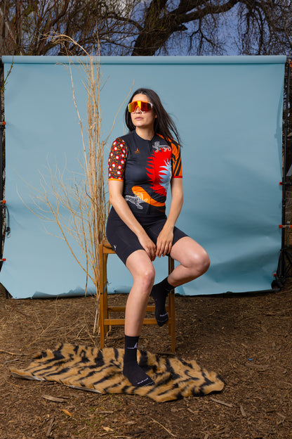 Woman sitting outdoors wearing Wild Bloom women's cycling jersey