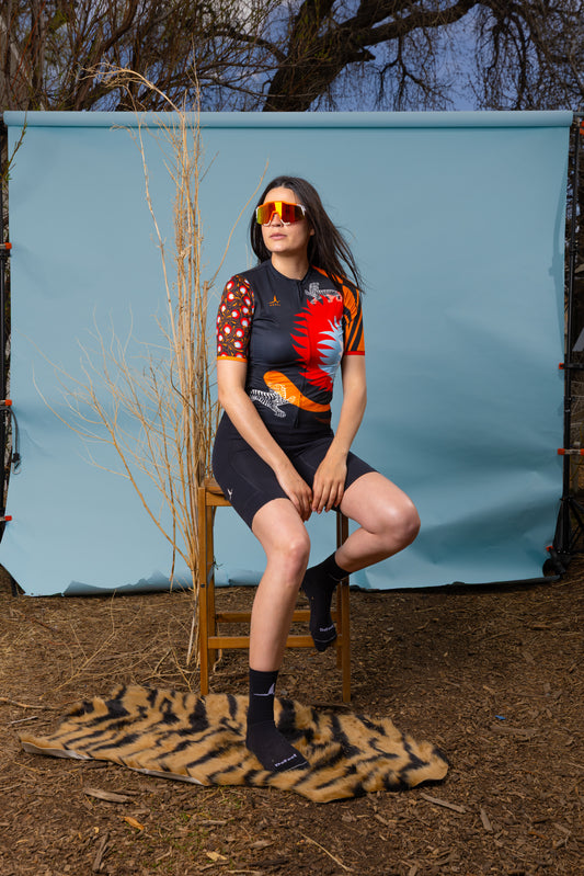 Woman sitting outdoors wearing Wild Bloom women's cycling jersey